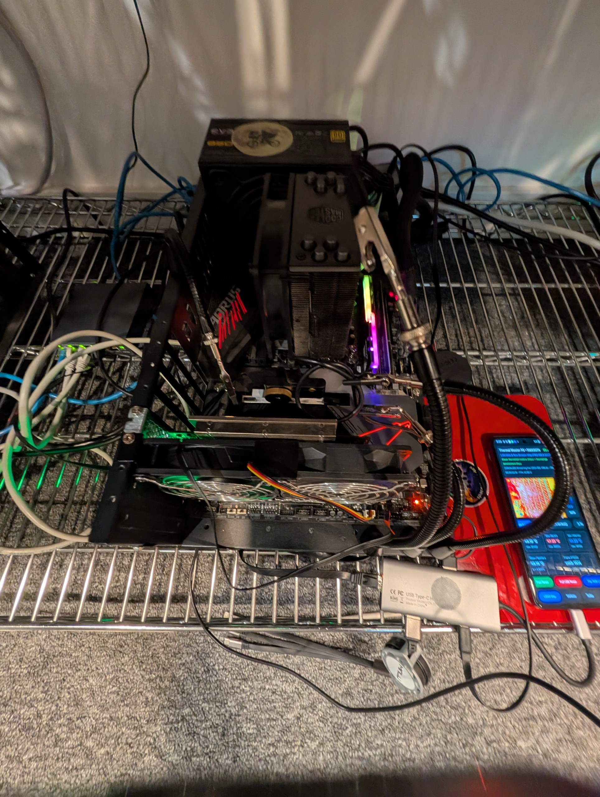 Physical setup showing Thermal Master P3 camera clamped on an articulating arm pointed at an open-bench PC motherboard, wired via USB-C hub to an Android phone running the streaming broadcaster app